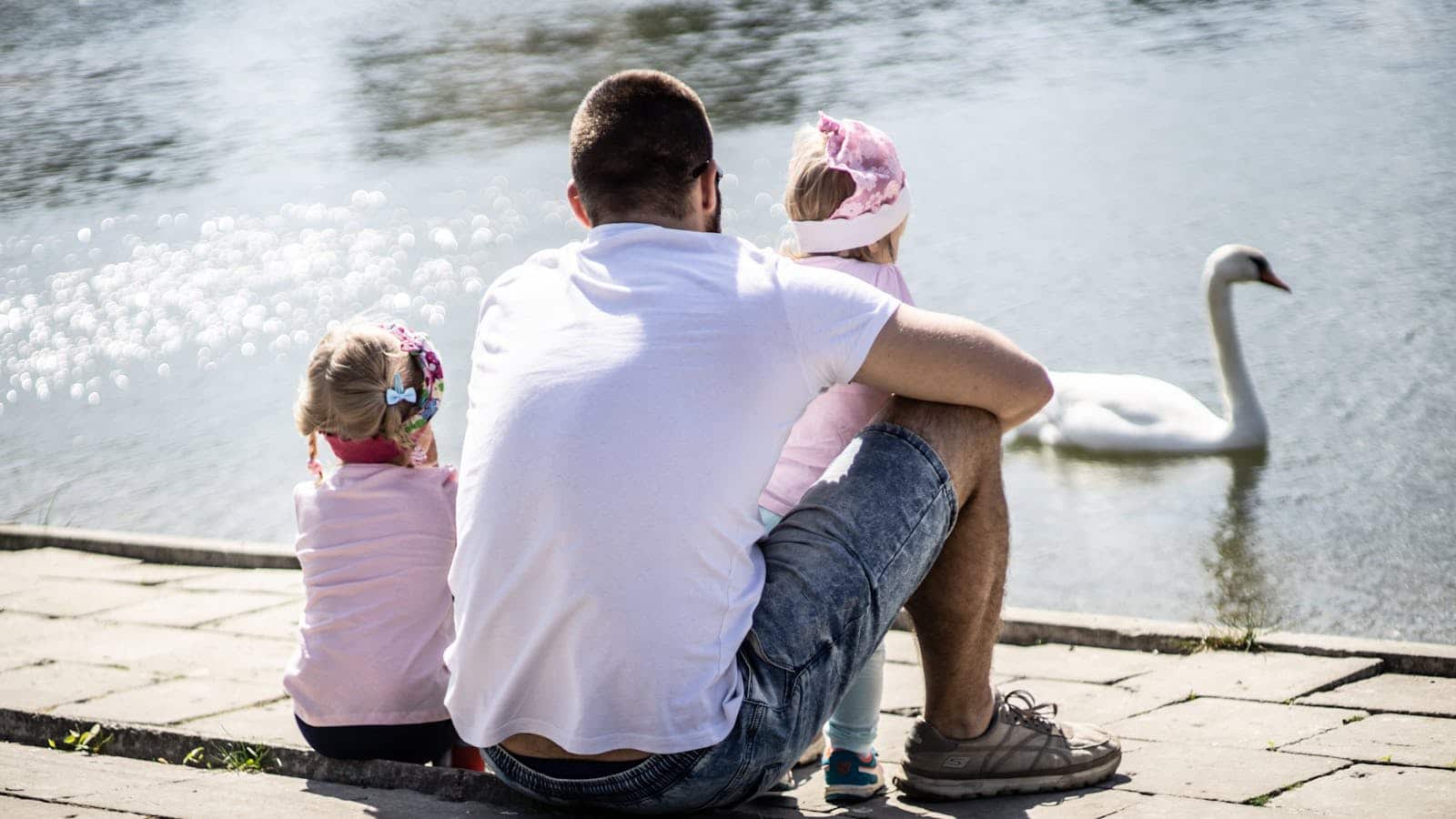 Girl Sitting Next to Man While Holding Baby